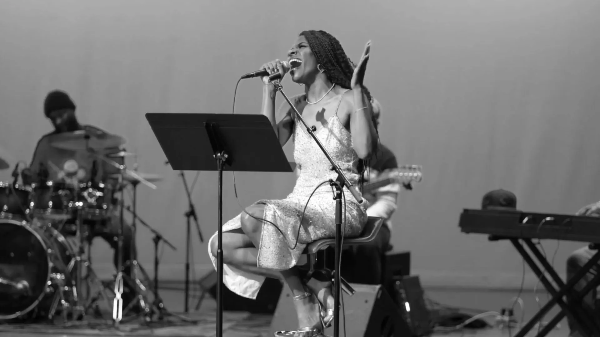 Een zangeres die met haar band optreedt op het podium van het American Jazz Museum