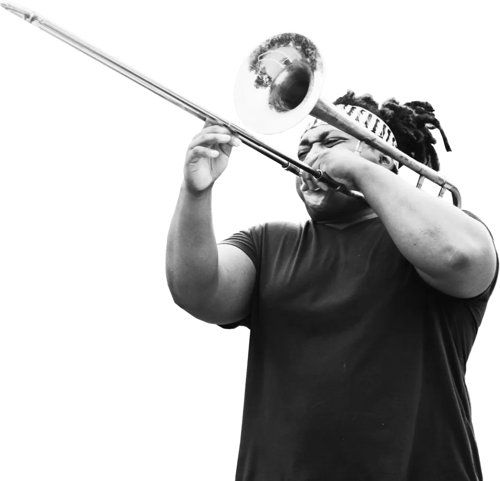 Man with a headband playing a trombone, captured in black and white.